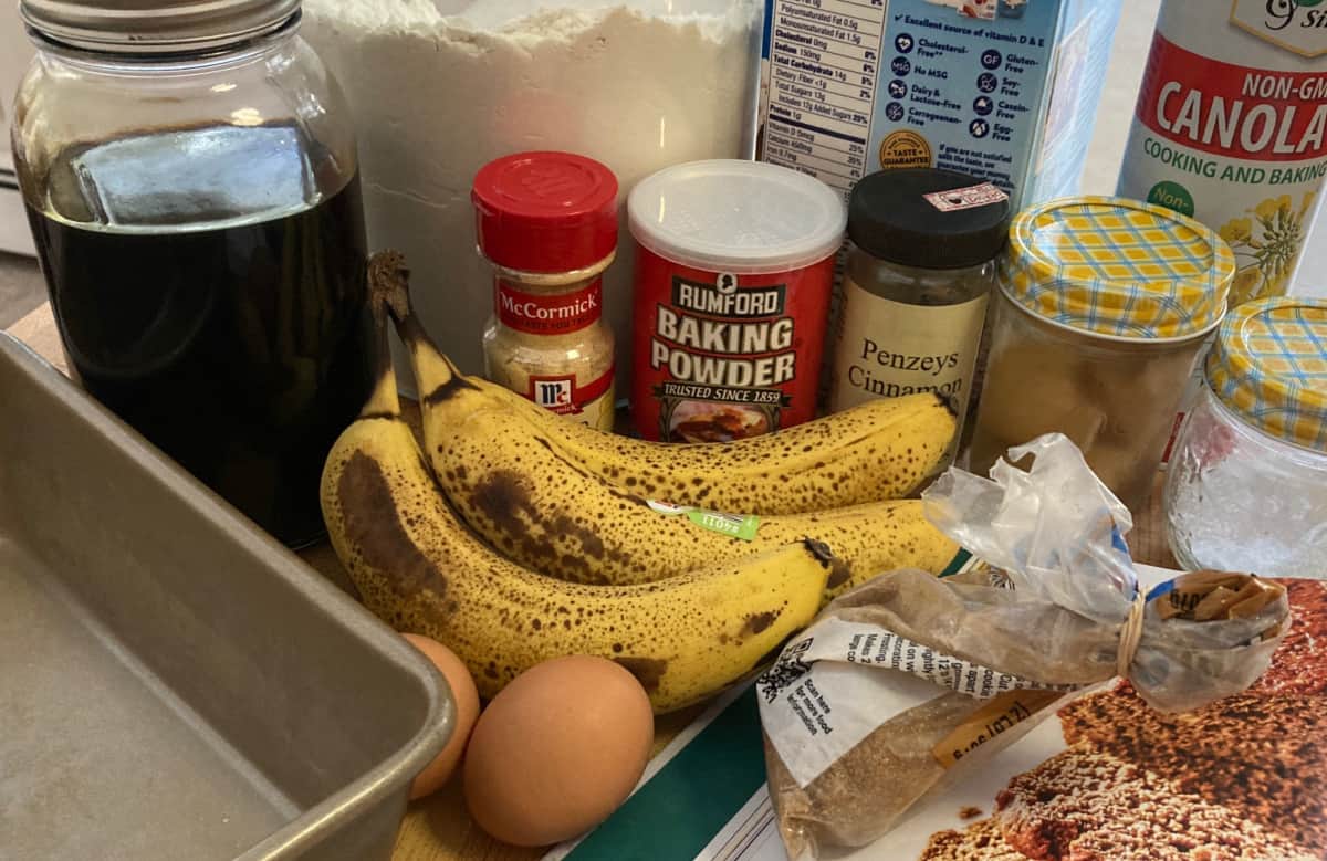 Ripe bananas, molasses, eggs and spices for making banana gingerbread.