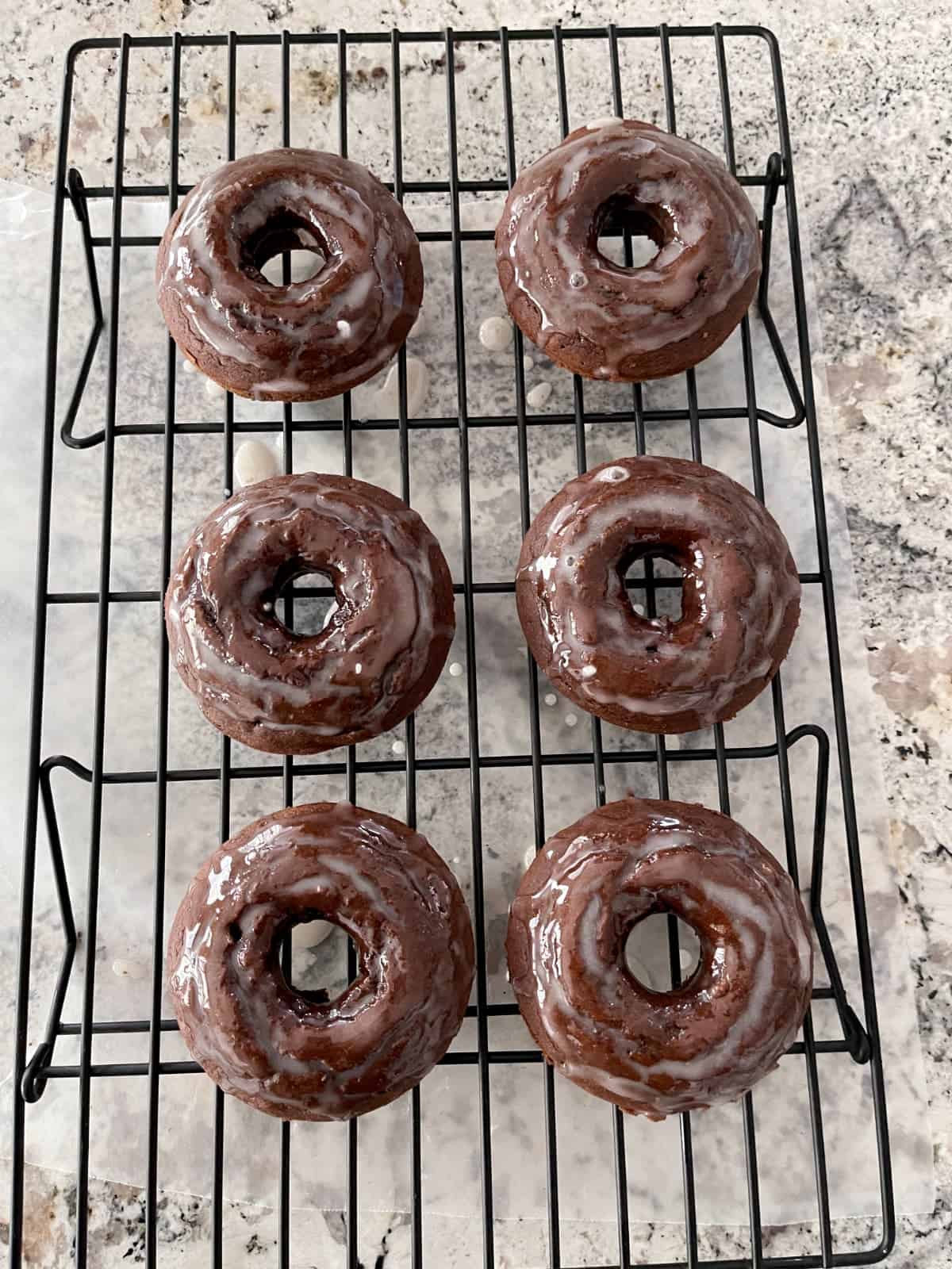 Mint chocolate glazed donuts on cooling rack.