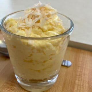 glass with 3-ingredient pineapple fluff with spoon behind