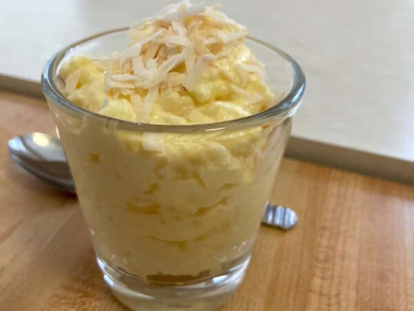 glass with 3-ingredient pineapple fluff with spoon behind