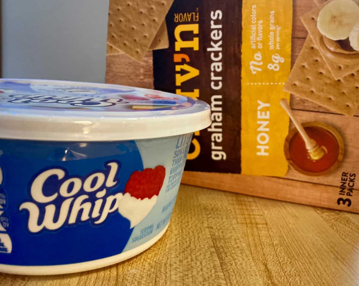 Container of Cool Whip and box of graham crackers.