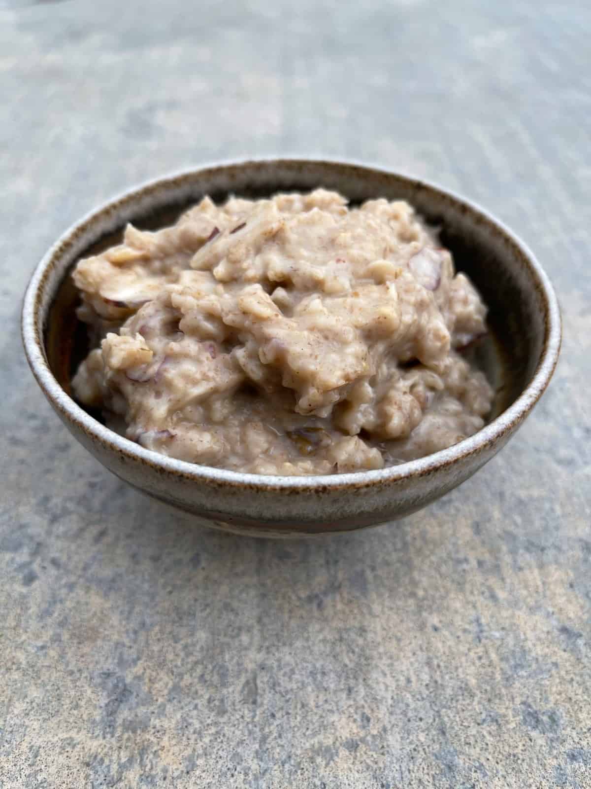 Slow cooker almond date oatmeal in brown ceramic bowl.