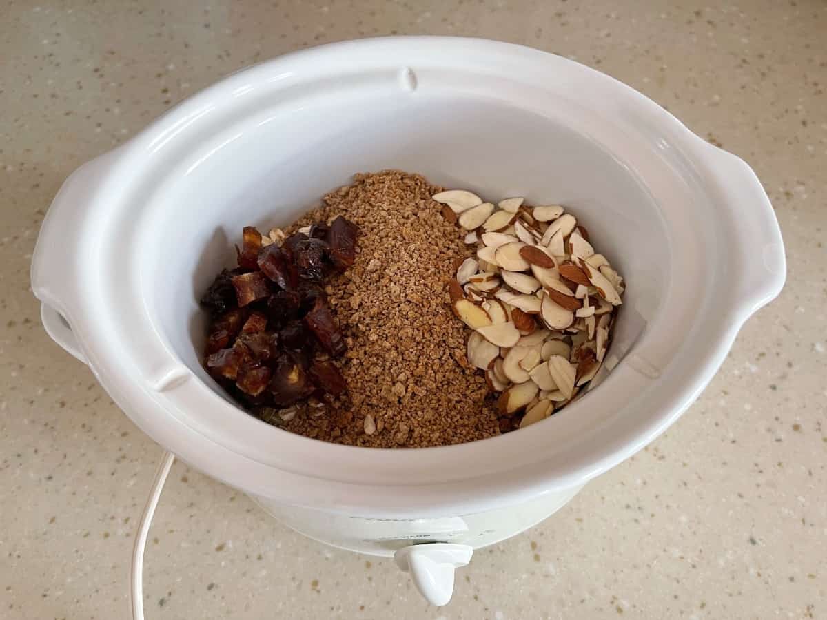 Crock pot with oats, Grape Nuts, chopped dates and sliced almonds.