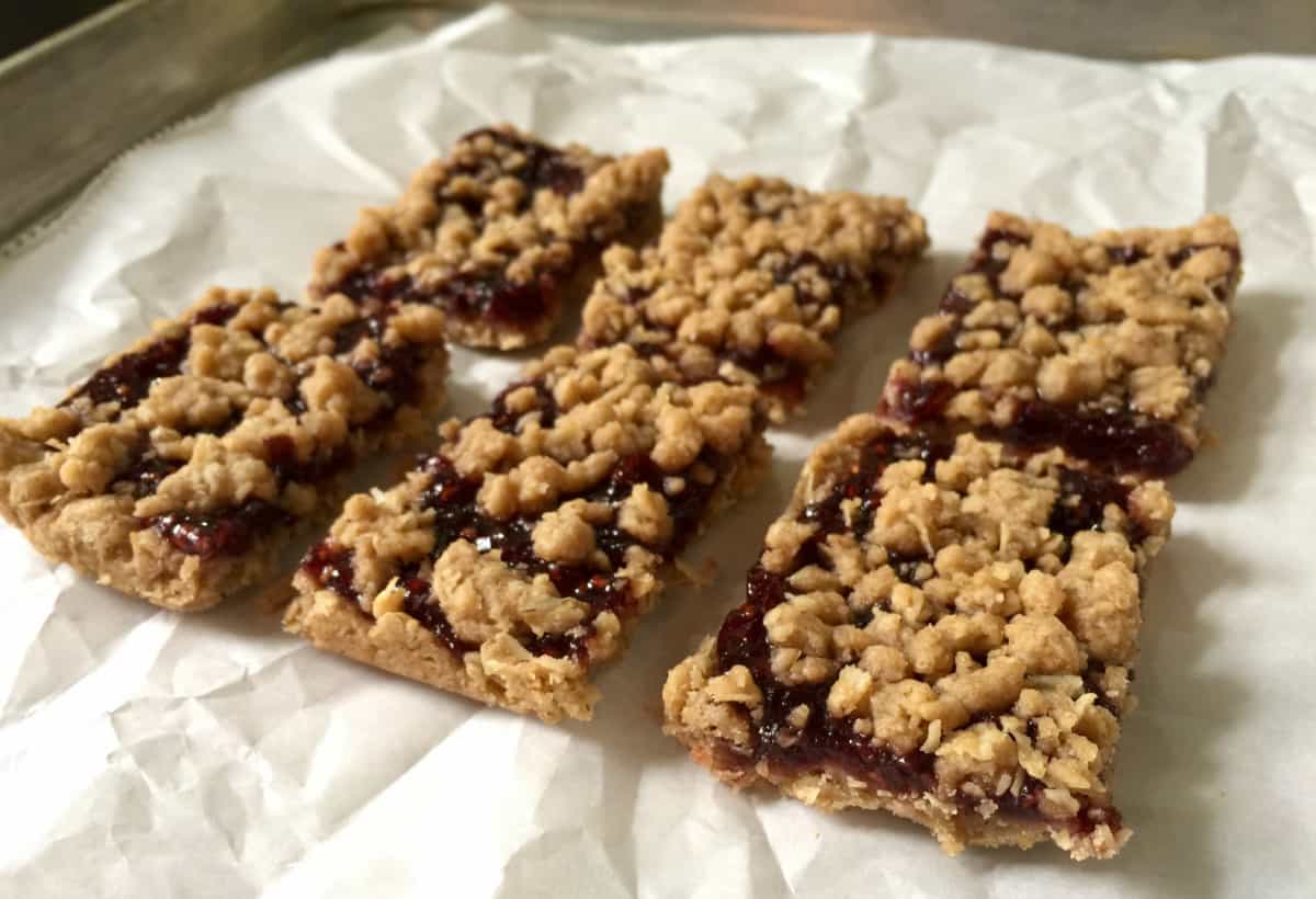 Cut raspberry bars on crumpled parchment paper.