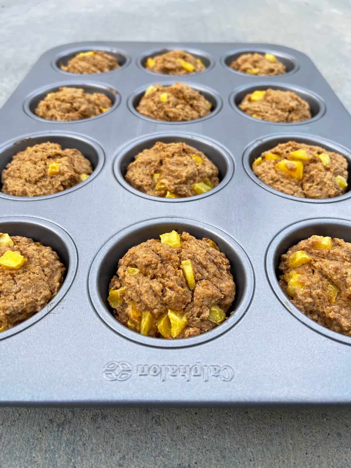 Fresh baked mango muffins in muffin pan.