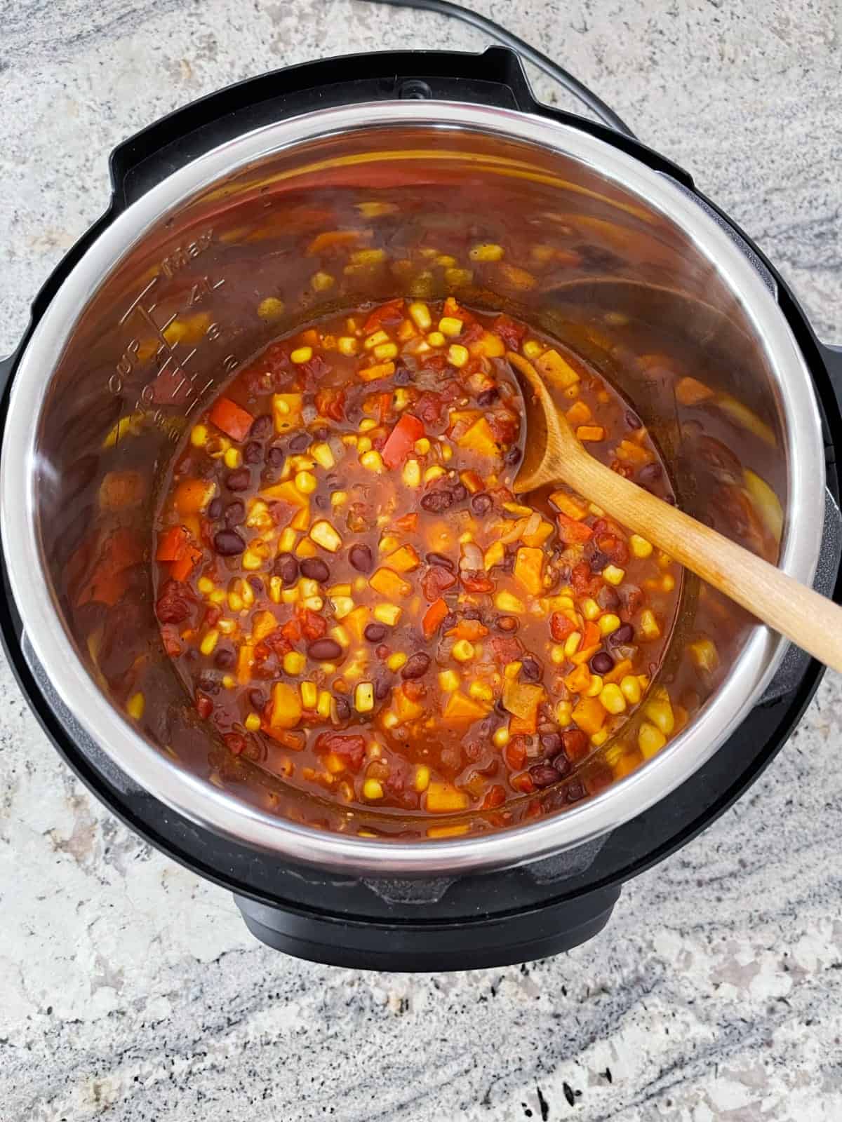 Stirring corn kernels into Instant Pot black bean sweet potato chili