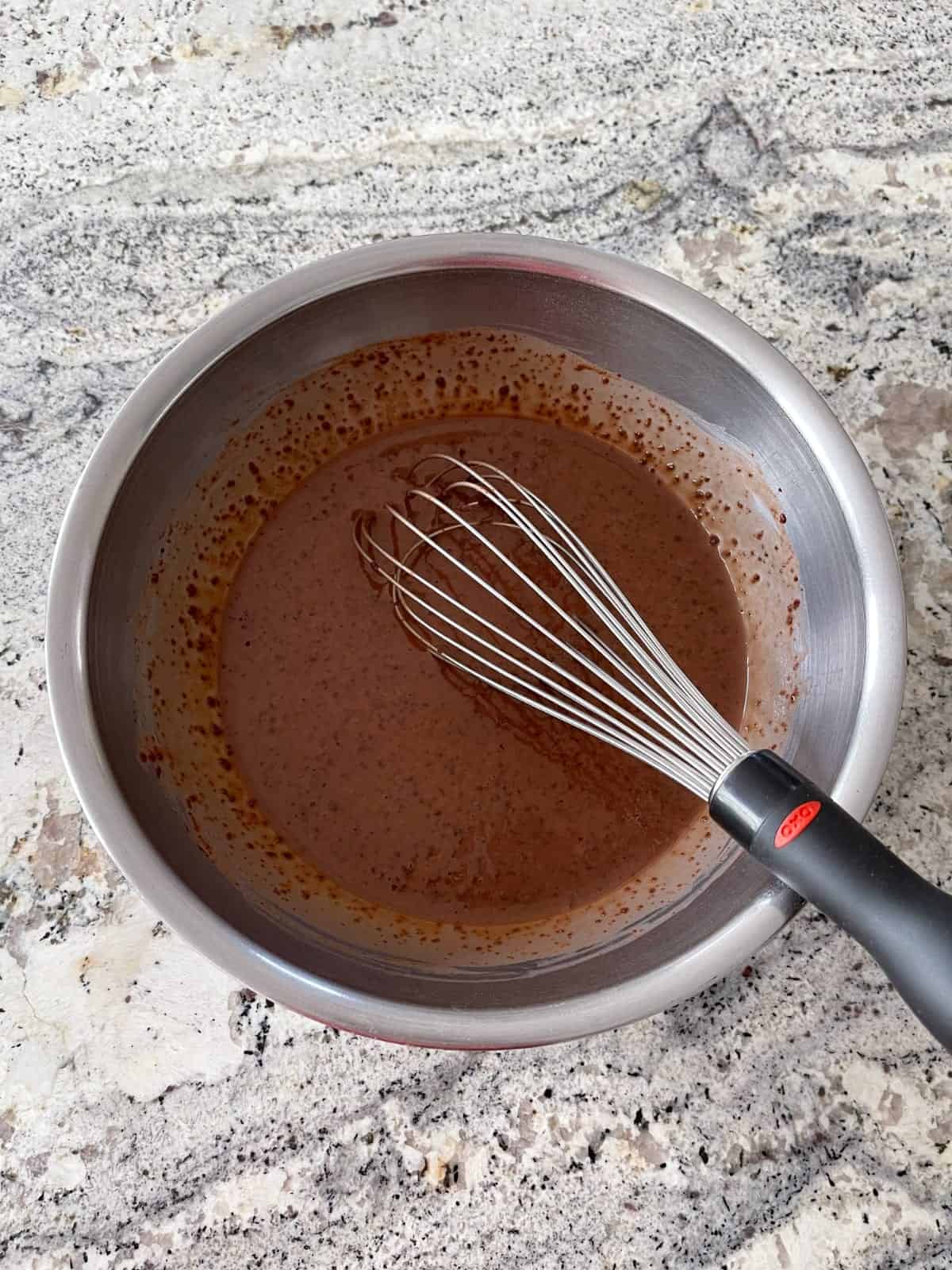 Whisking sugar-free instant chocolate pudding mix and almond milk in mixing bowl.