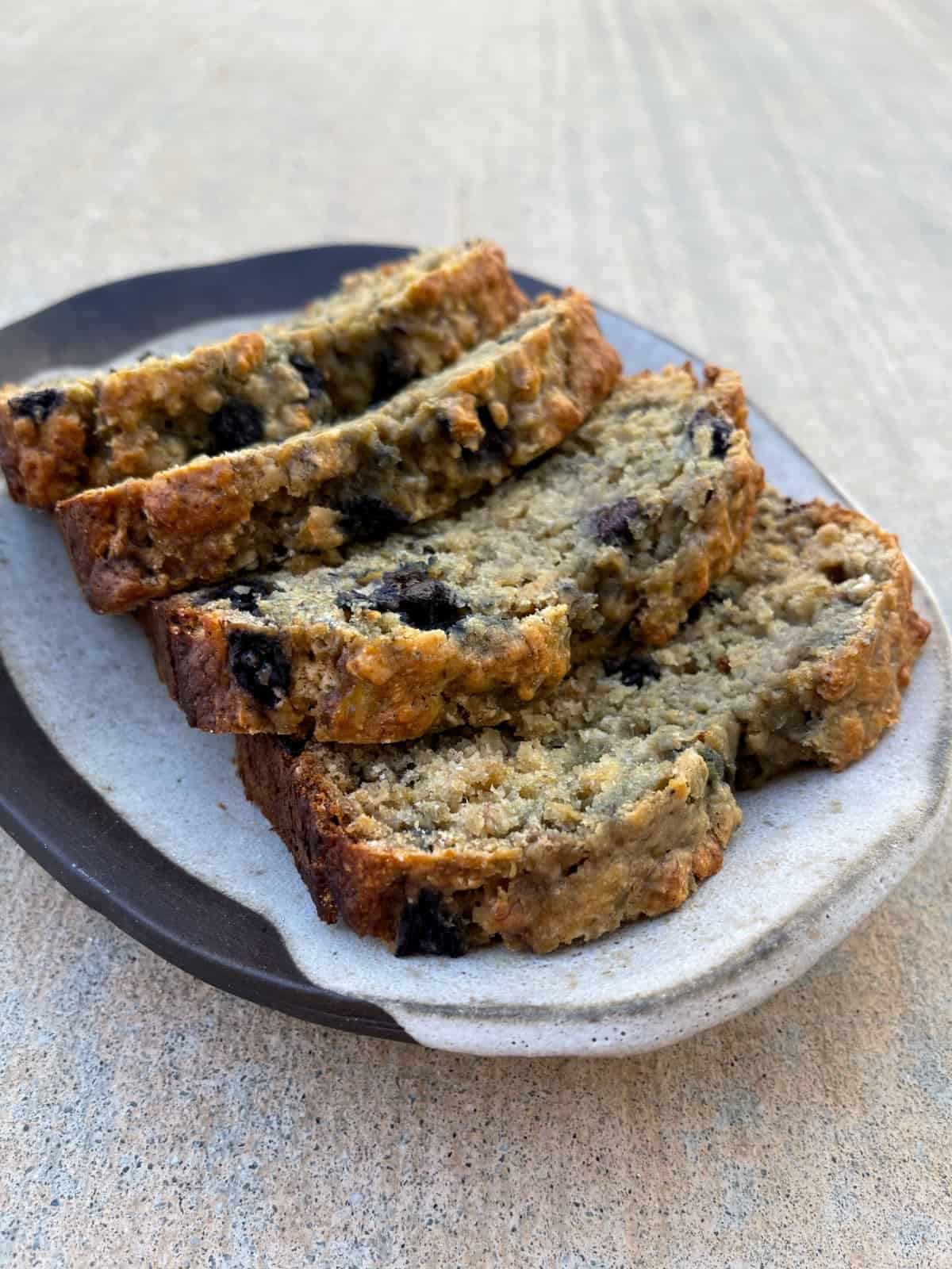 Blueberry banana bread slices on pottery plate.