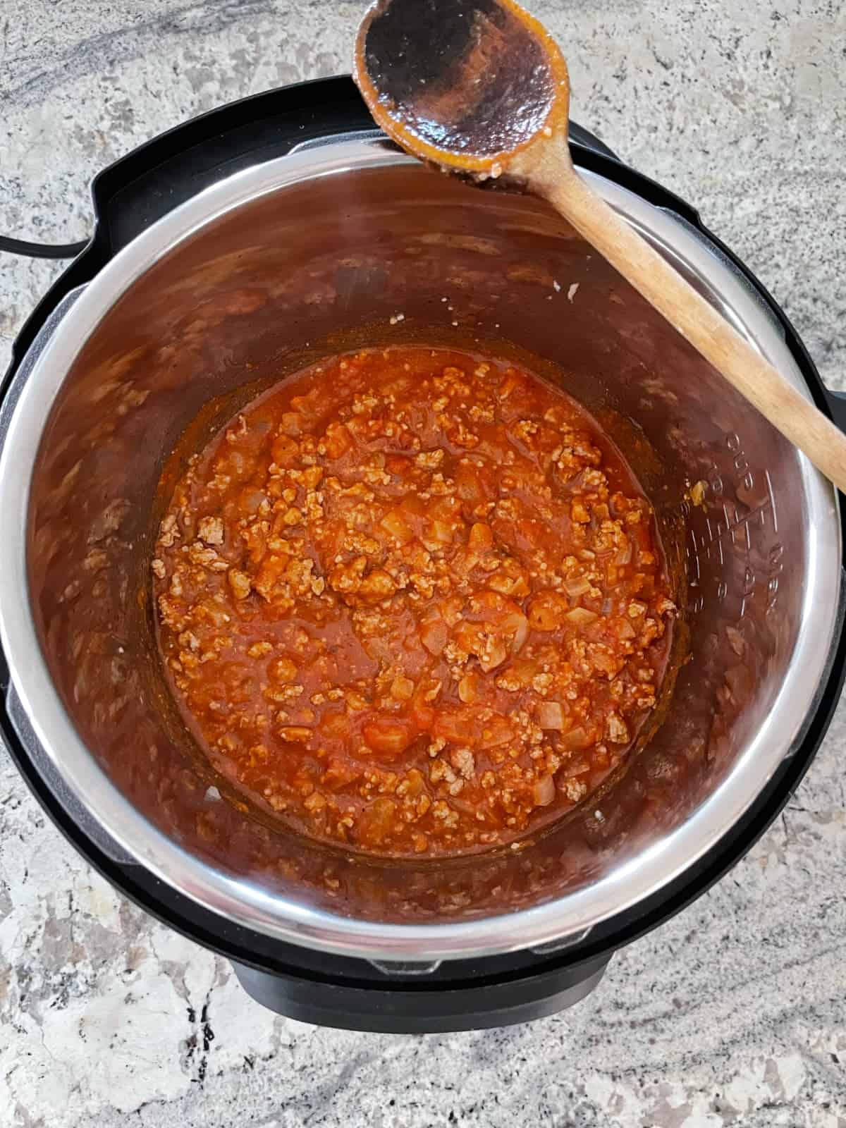 Cooking marinara sauce with ground turkey and onions in instant pot.