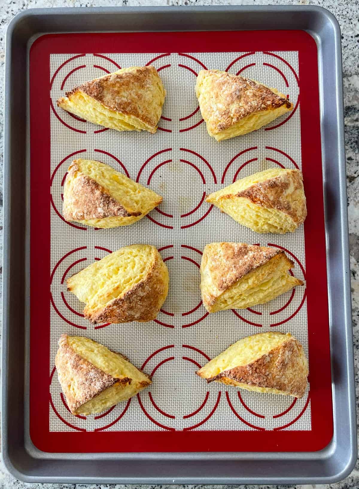 Orange scones on baking sheet.