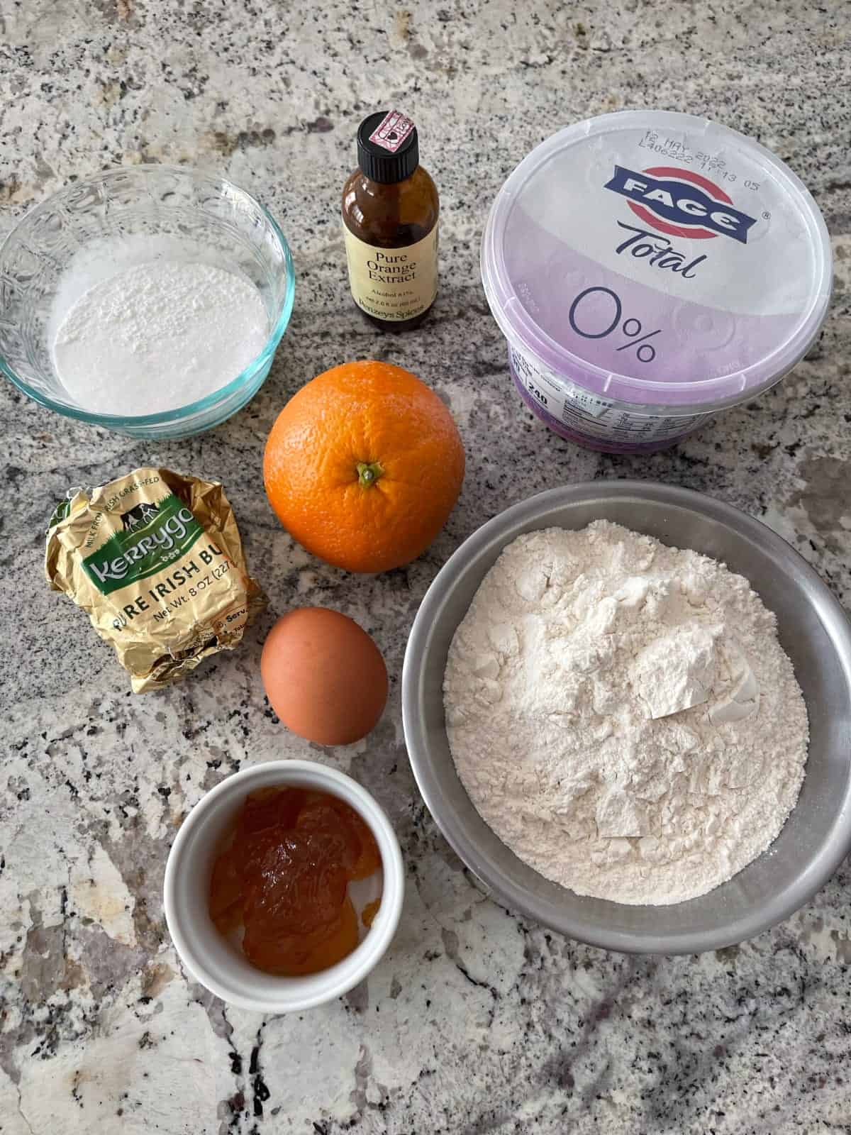 Ingredients including all-purpose flour, plain Greek yogurt, orange, butter, egg, orange marmalade and monkfruit sweetener.