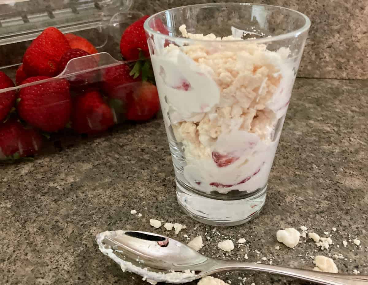 Strawberry meringue mousse in dessert glass with spoon.