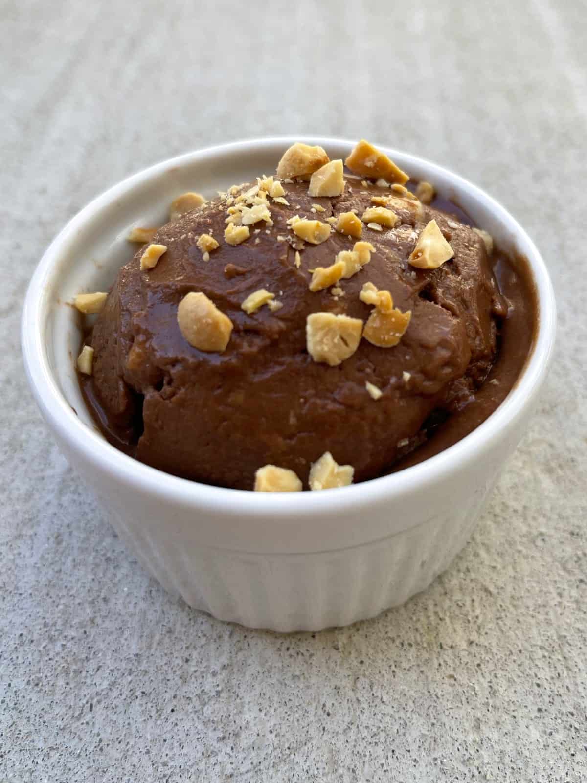 Peanut butter chocolate nice cream topped with chopped salted peanuts.