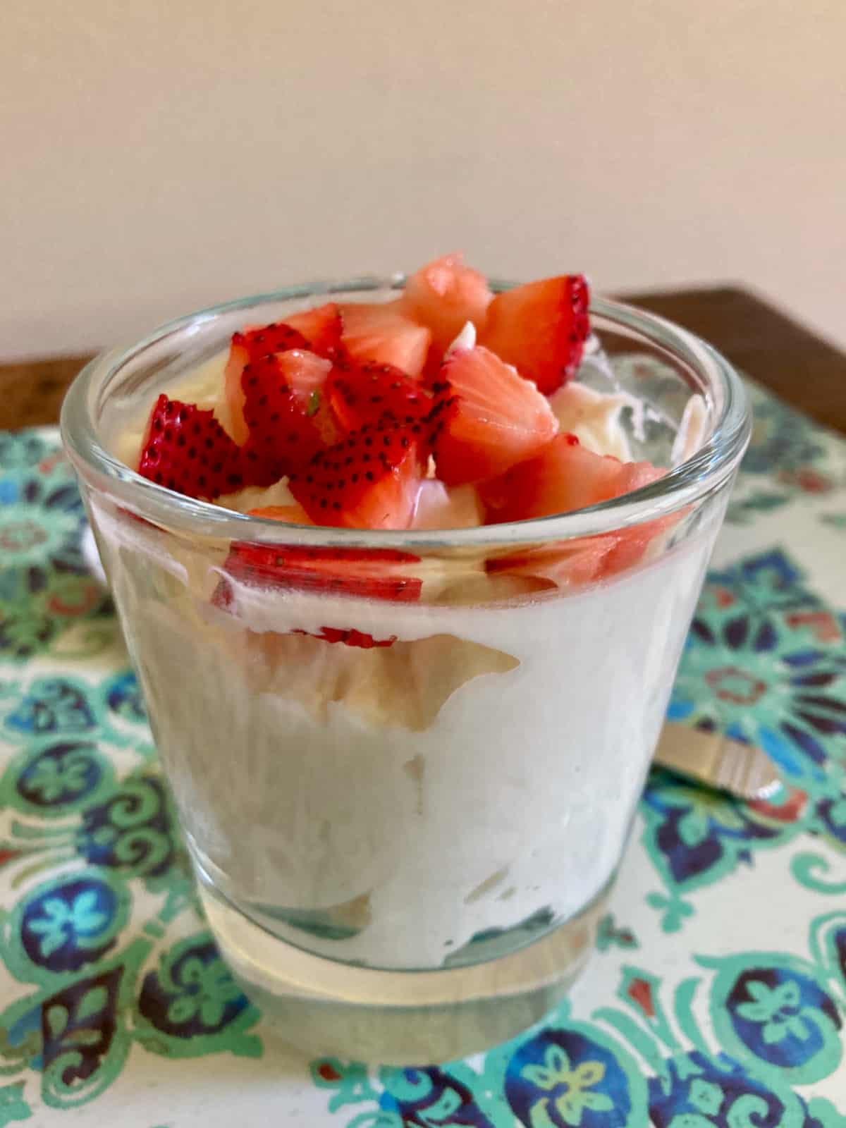 Vanilla yogurt fluff topped with fresh chopped strawberries in dessert glass.