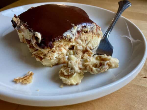 easy icebox eclair dessert on white plate with fork from front