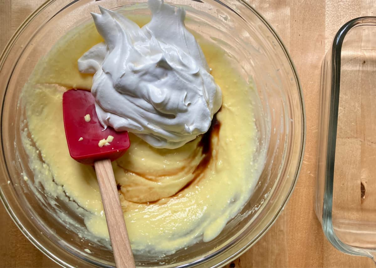 Folding vanilla and whipped topping into pudding mixture with spatula.