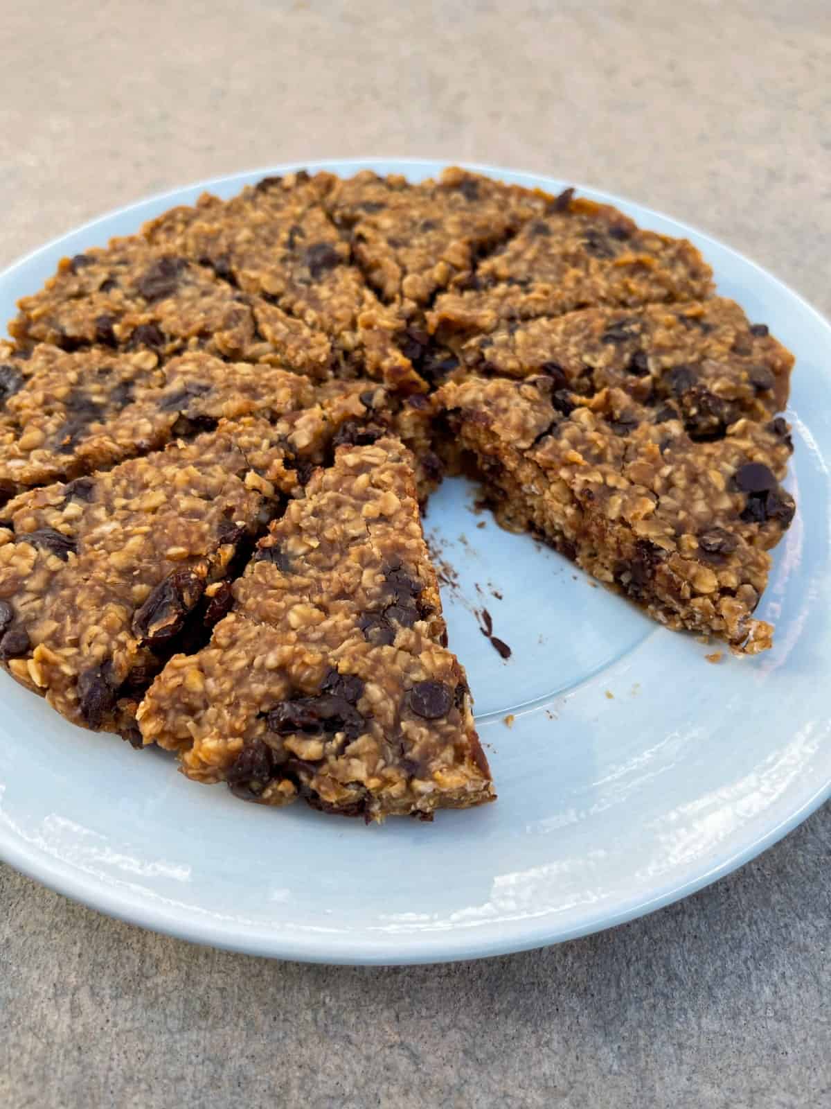 Chewy peanut butter raisin chocolate chip granola bars on serving plate.