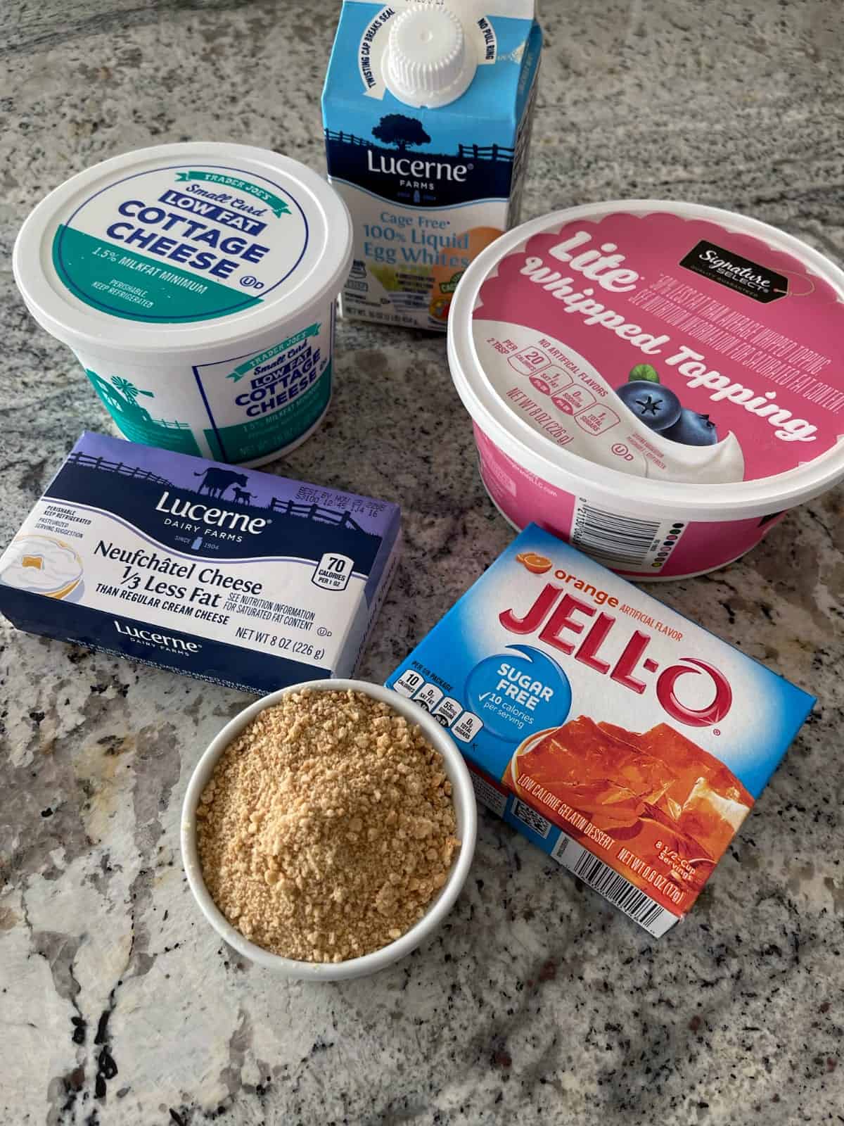 Ingredients including graham cracker crumbs, orange Jello, light cream cheese, low fat cottage cheese, lite whipped topping and egg whites.