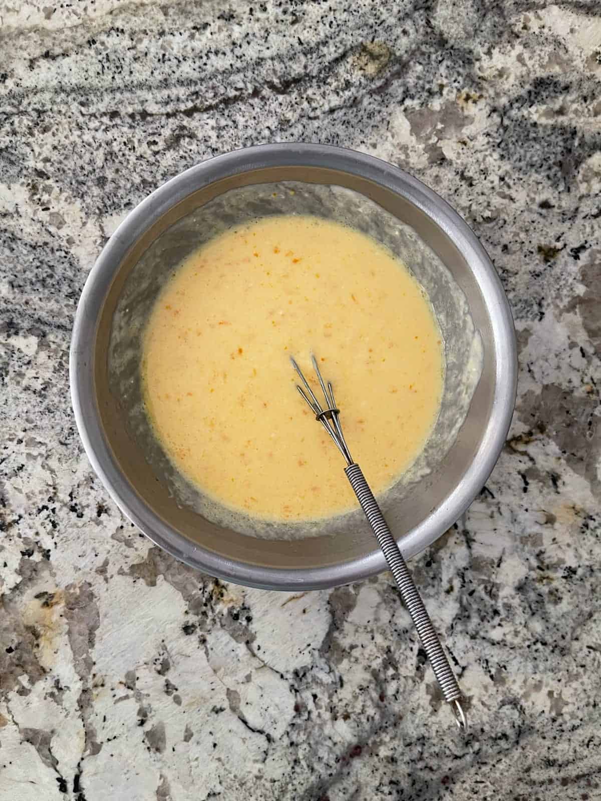 Whisking yogurt, egg, butter and orange zest in mixing bowl.