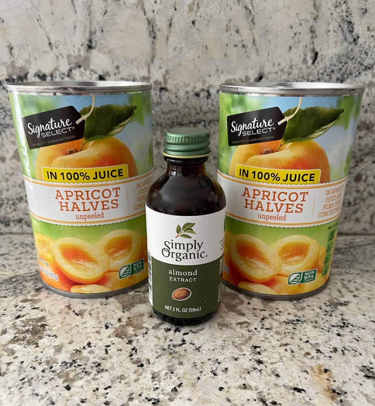 Two cans apricot halves in juice with small bottle almond extract.