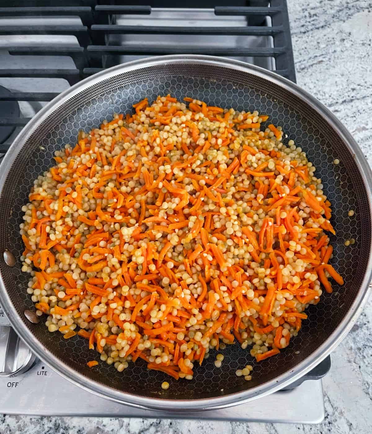 Carrot couscous skillet on stovetop.