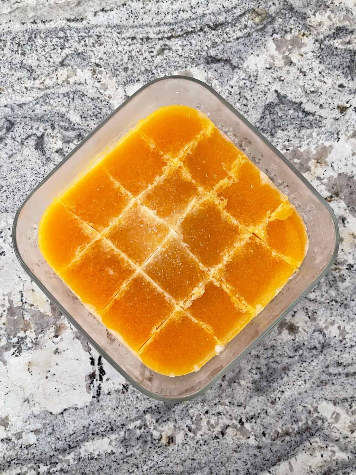 Frozen apricot puree in glass container cut into cubes.
