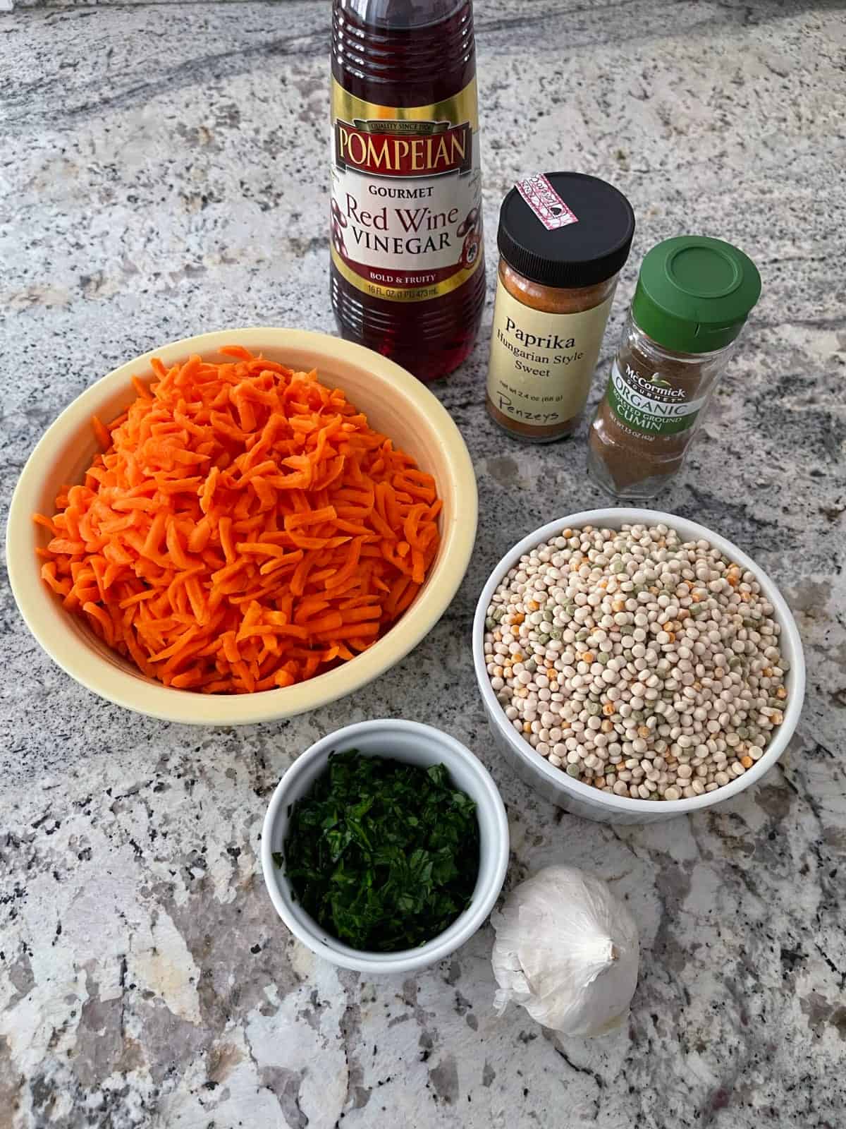 Ingredients including Israeli couscous, shredded carrots, chopped parsley, paprika, cumin and red wine vinegar.