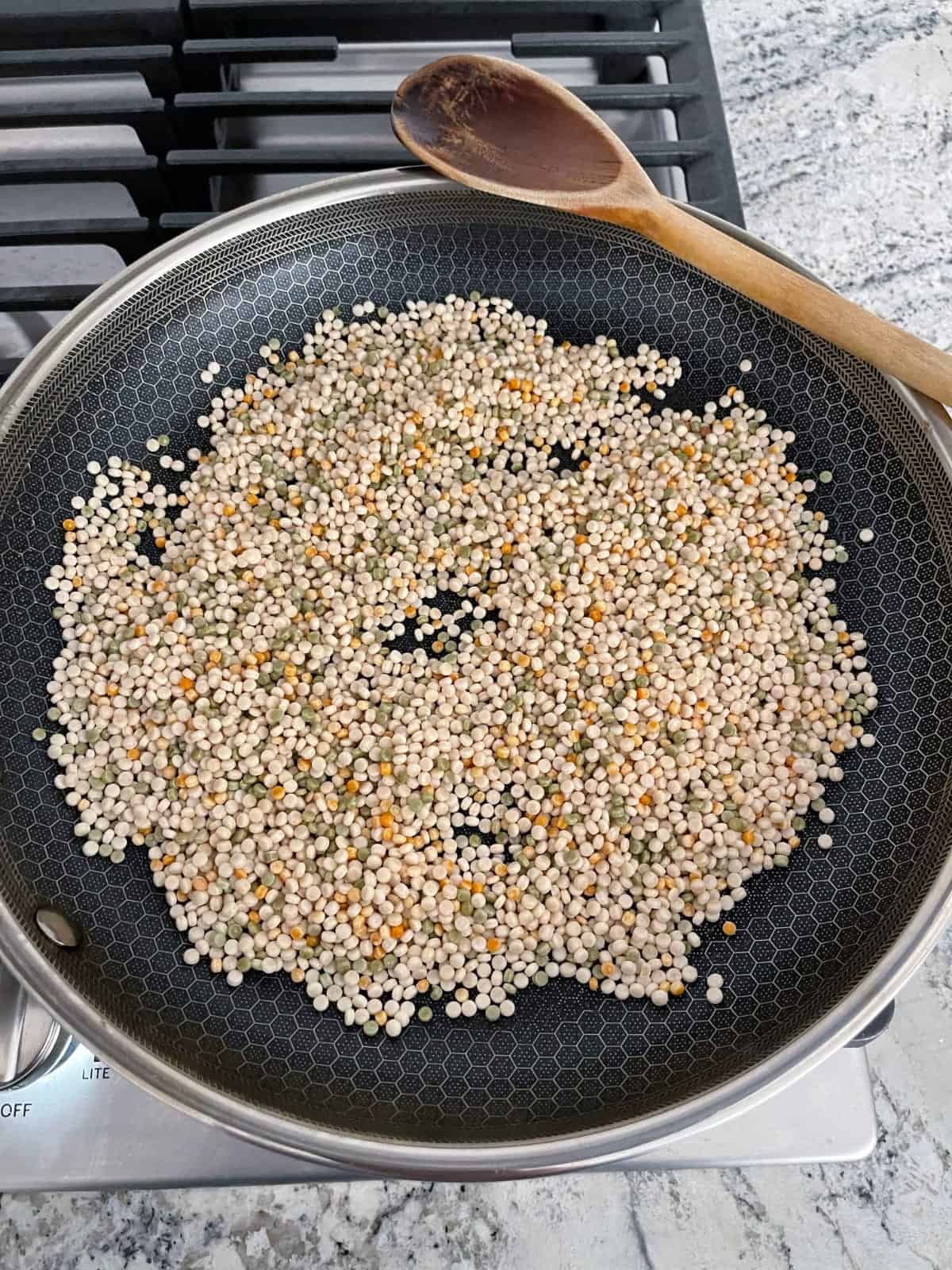 Toasting Israeli couscous in large skillet.