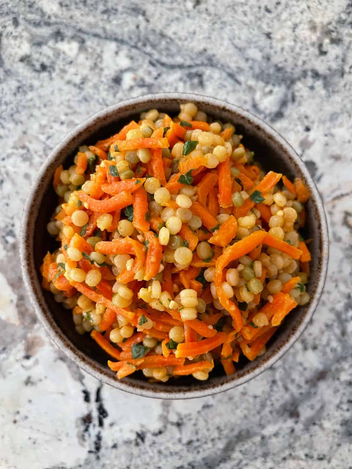Moroccan carrot couscous salad in ceramic bowl.