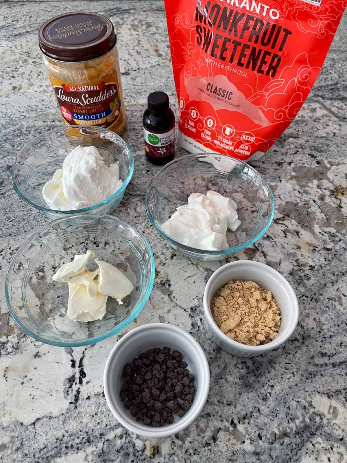 Ingredients including peanut butter, monk fruit sweetener, vanilla yogurt, cream cheese, peanut butter powder and mini chocolate chips.