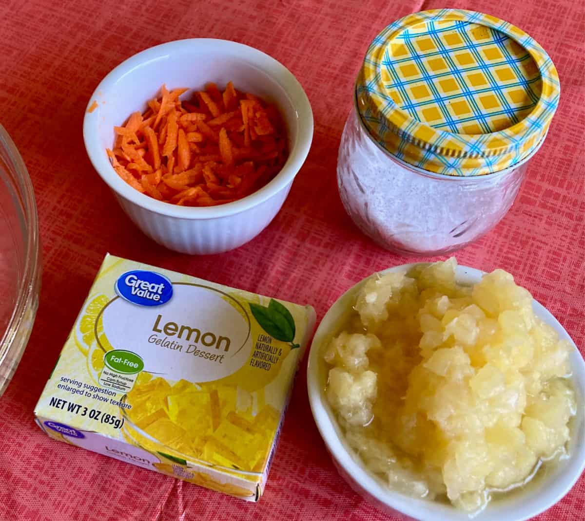 Ingredients including shredded carrot, crushed pineapple and package of lemon gelatin.