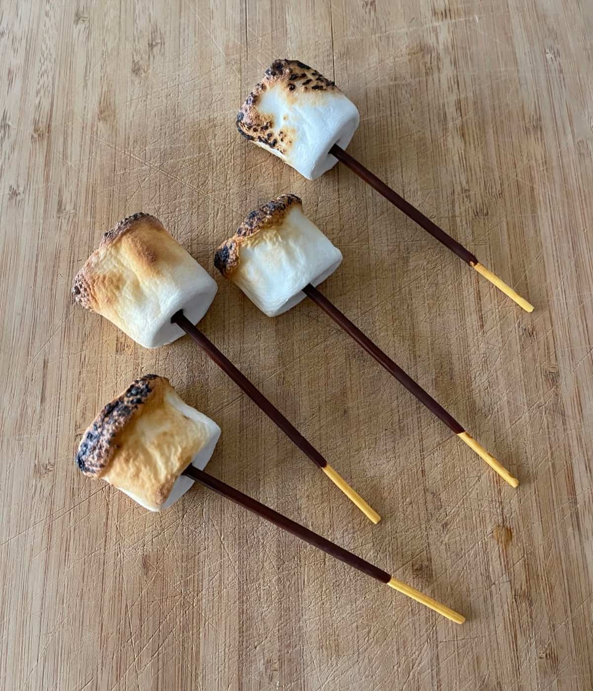 Pocky S'mores Pops on wood cutting board.