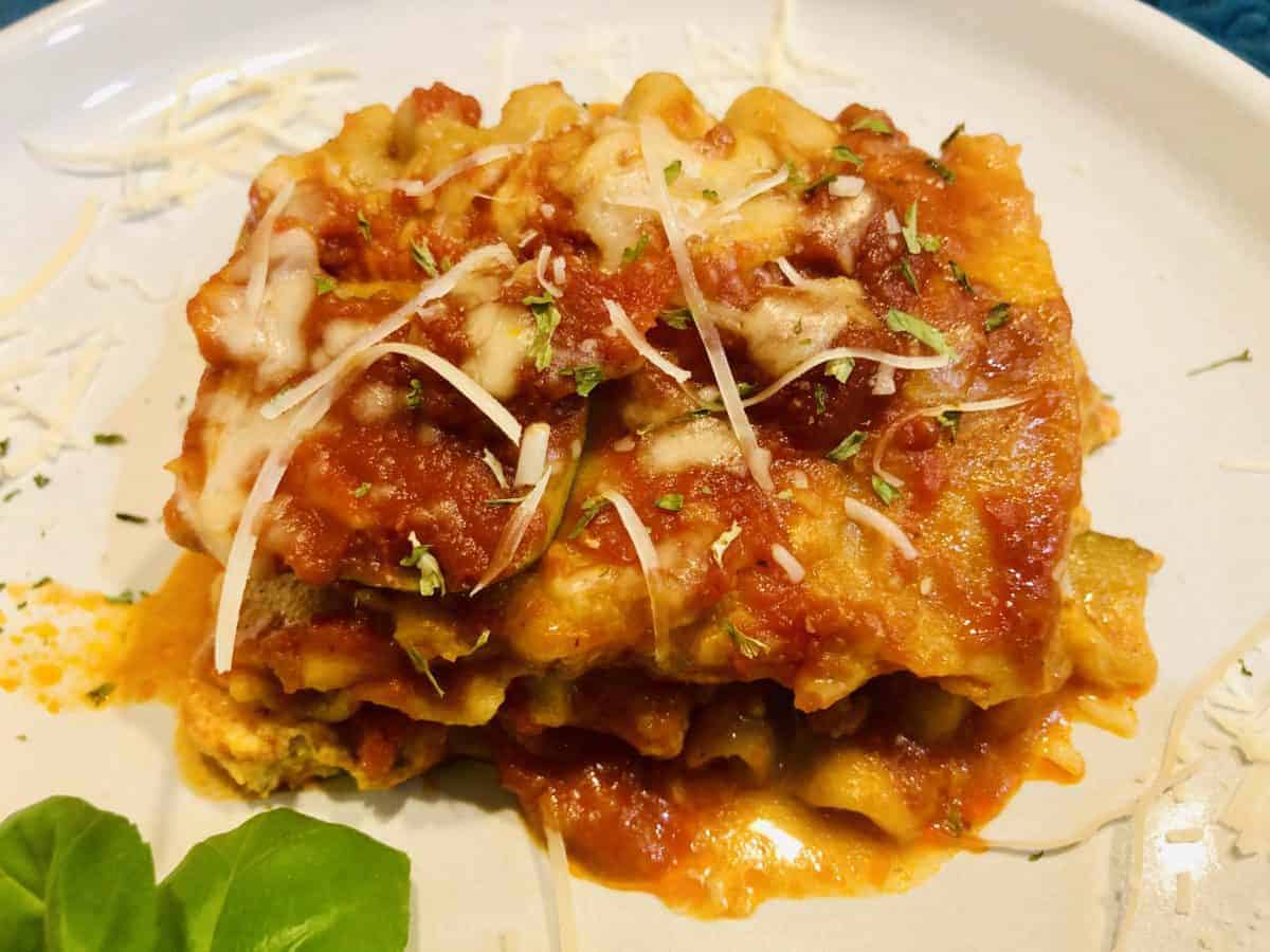 Piece of slow cooker chicken zucchini lasagna on small white plate.