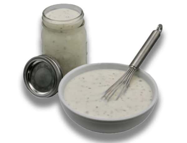 Homemade ranch dressing in bowl with whisk.
