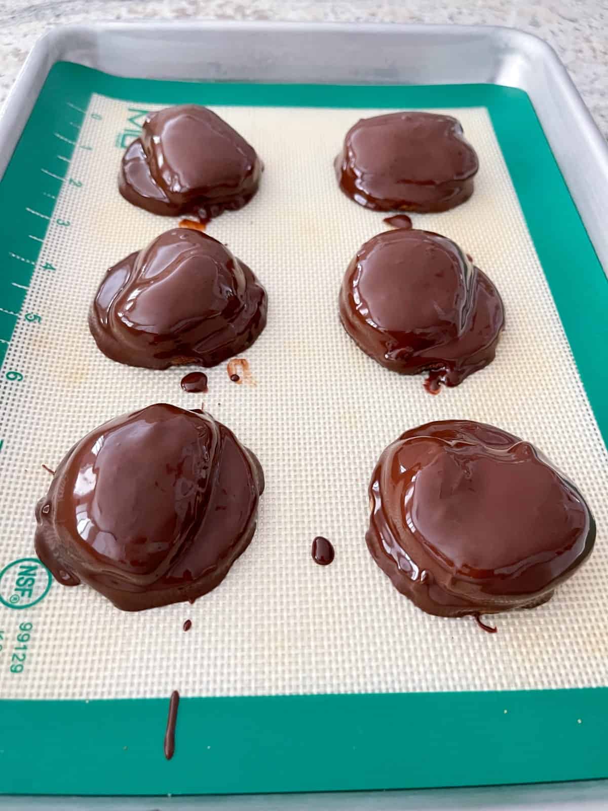 Chocolate marshmallow fluff cookies on silicone line quarter sheet pan.