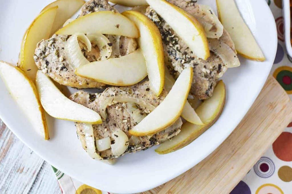 Pork Chops with sliced sauteed pears on white plate.