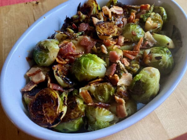 skillet roasted brussels sprouts with bacon in oval white ceramic dish