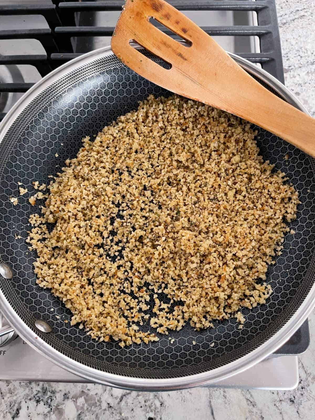 Toasting panko bread crumbs in butter in skillet on stove top.