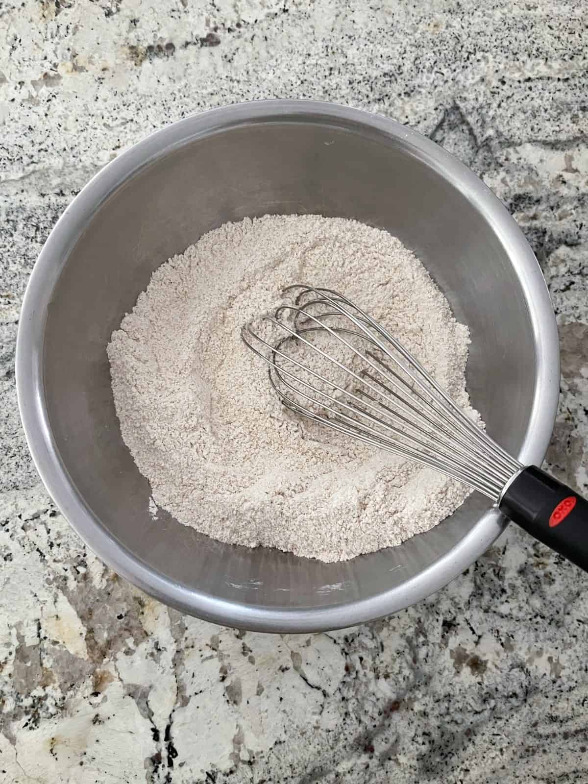 Mixing bowl with all-purpose flour, wheat flour, baking soda, baking powder, cinnamon, salt and sweetener and whisk.
