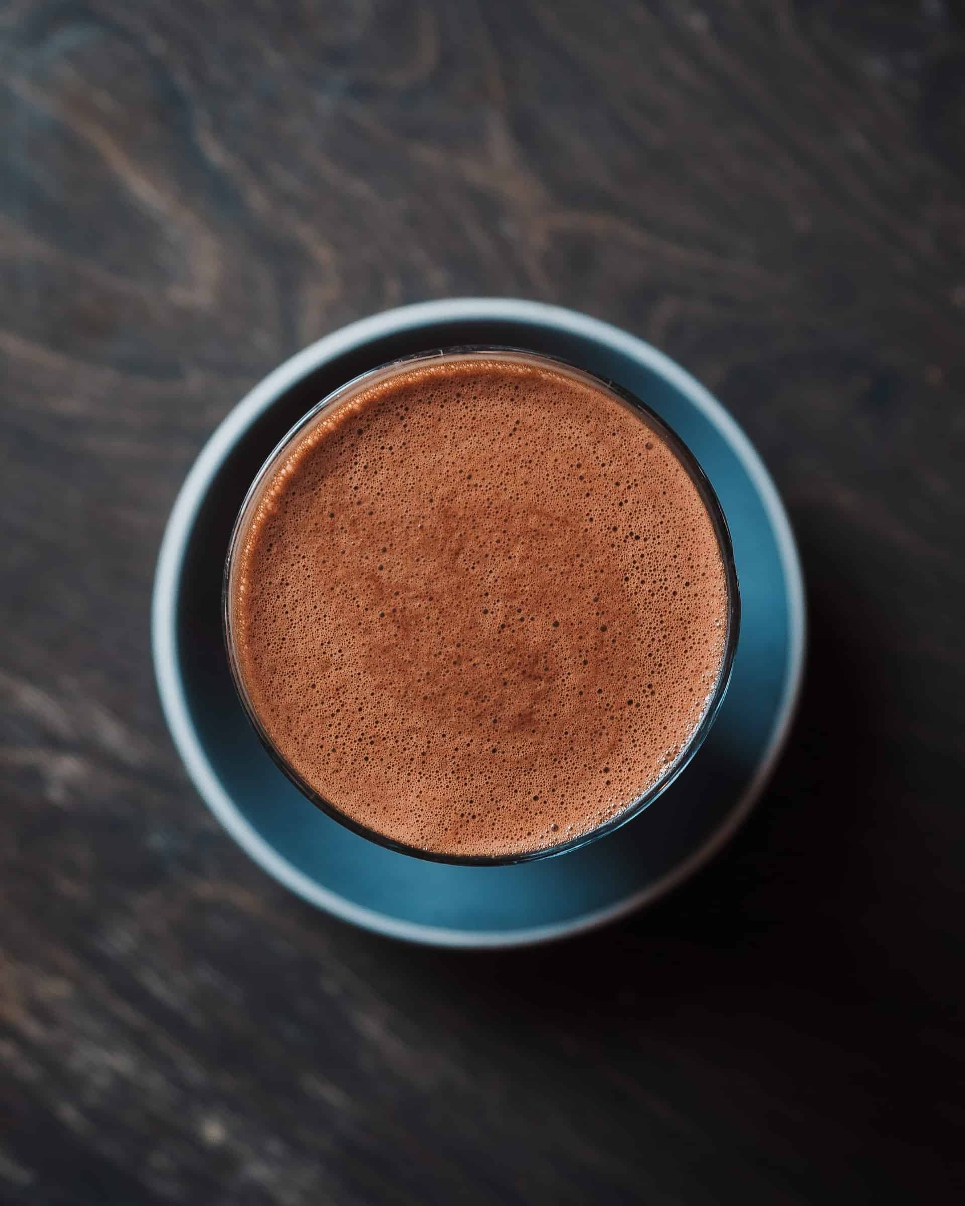 Hot chocolate blue bowl on dark background shot from above.