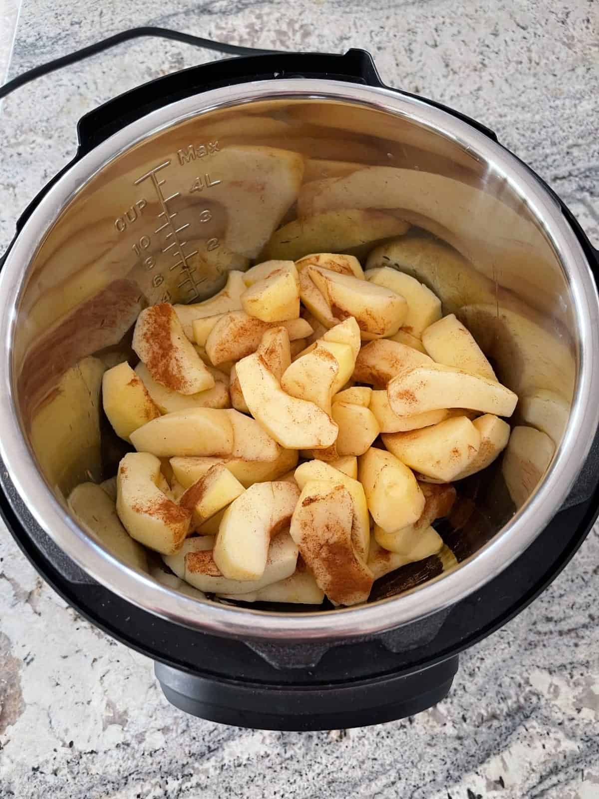 Ξεφλουδίστε και κόψτε τα μήλα σε φέτες με αλεσμένη κανέλα στο InstantPot.