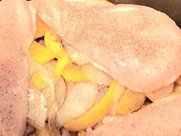 raw chicken & onions in crock pot with text: "The Ultimate Guide to Cooking Chicken in the CrockPot"