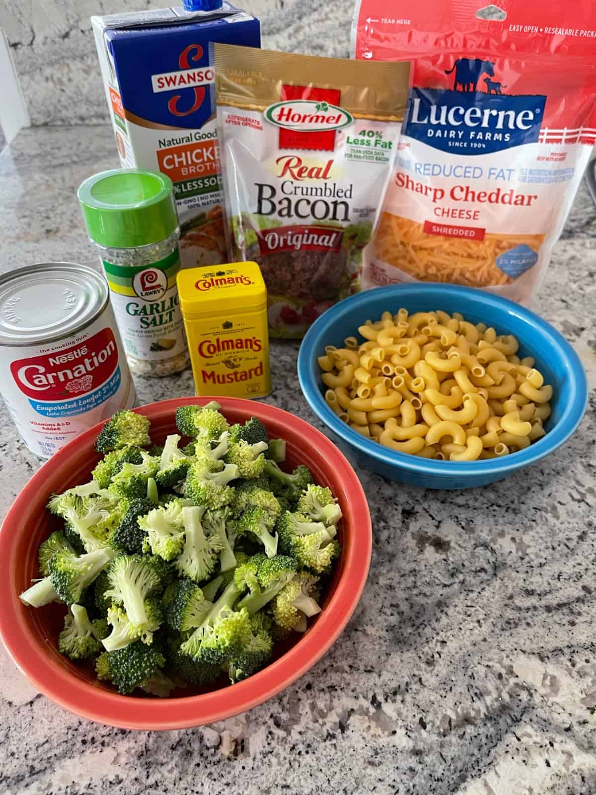 Broccoli florets, macaroni, cheddar cheese, real bacon bits and spices for making macaroni and cheese.