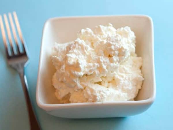 white square dish filled with cottage cheese on a blue counter