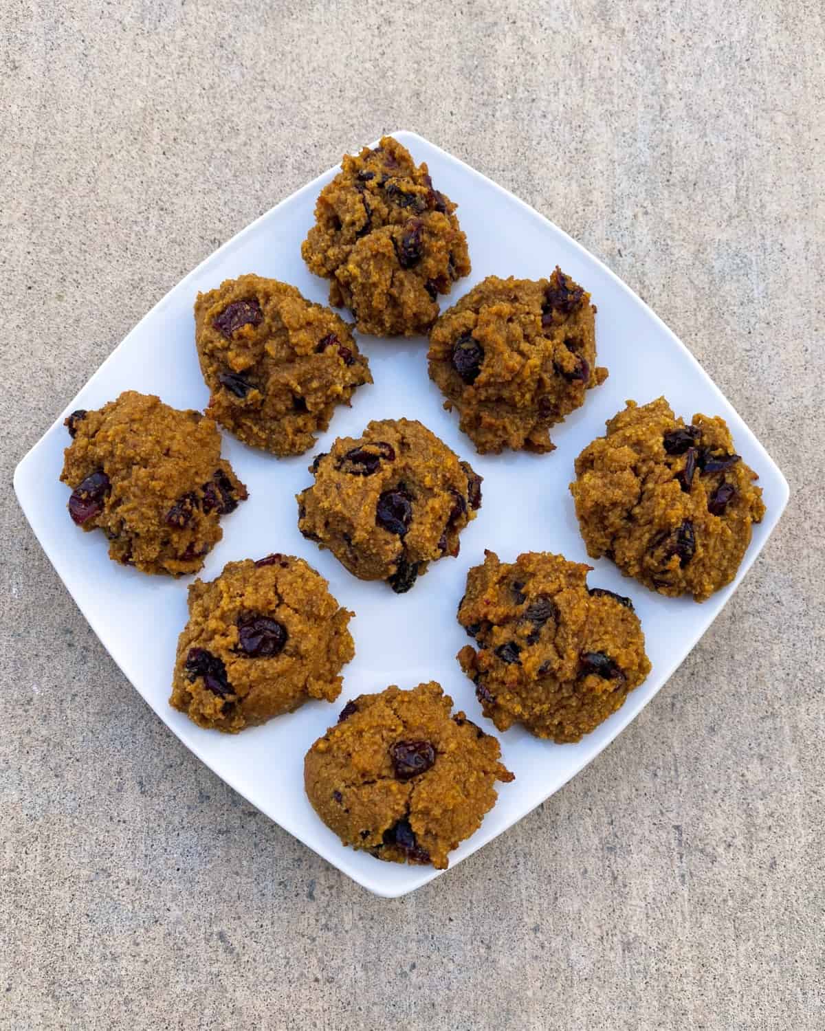 Fresh baked gluten-free pumpkin quinoa cranberry cookies on serving platter from above.