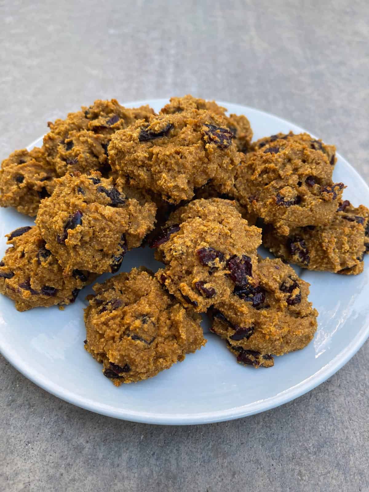 Fresh baked pumpkin quinoa cranberry cookies on small serving platter.