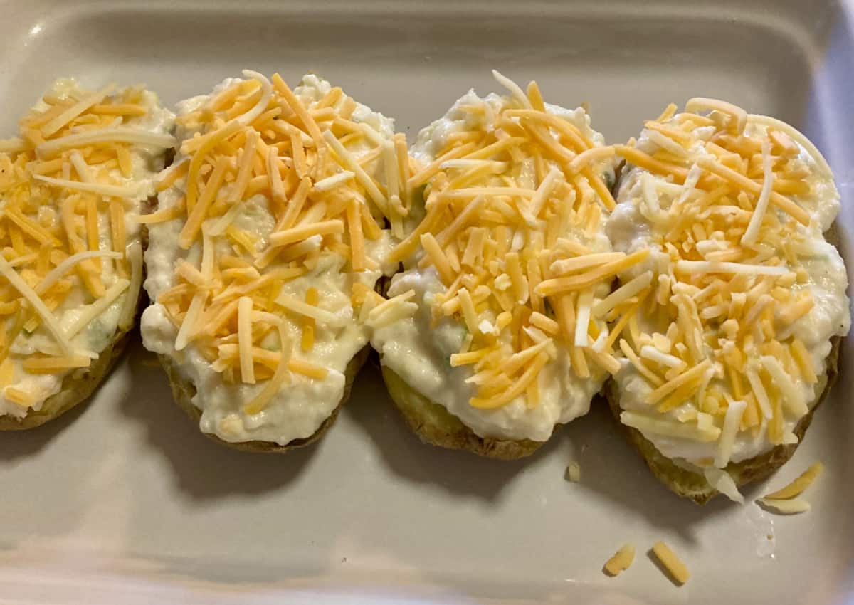 Filled stuffed twice baked potatoes in white baking dish.