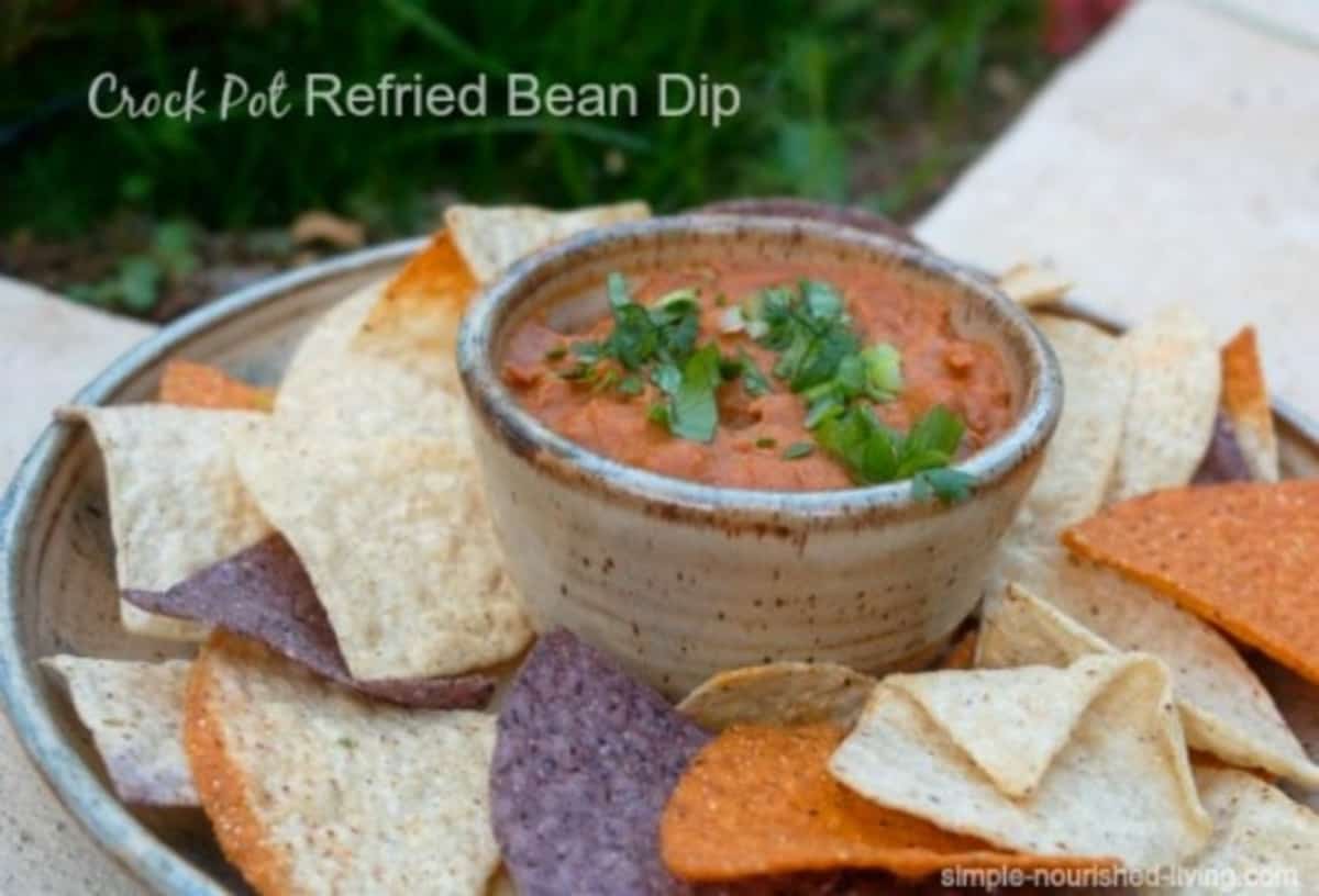 Bean Dip In Pottery Chip and Dip Dish Surrounded by assorted color corn chips