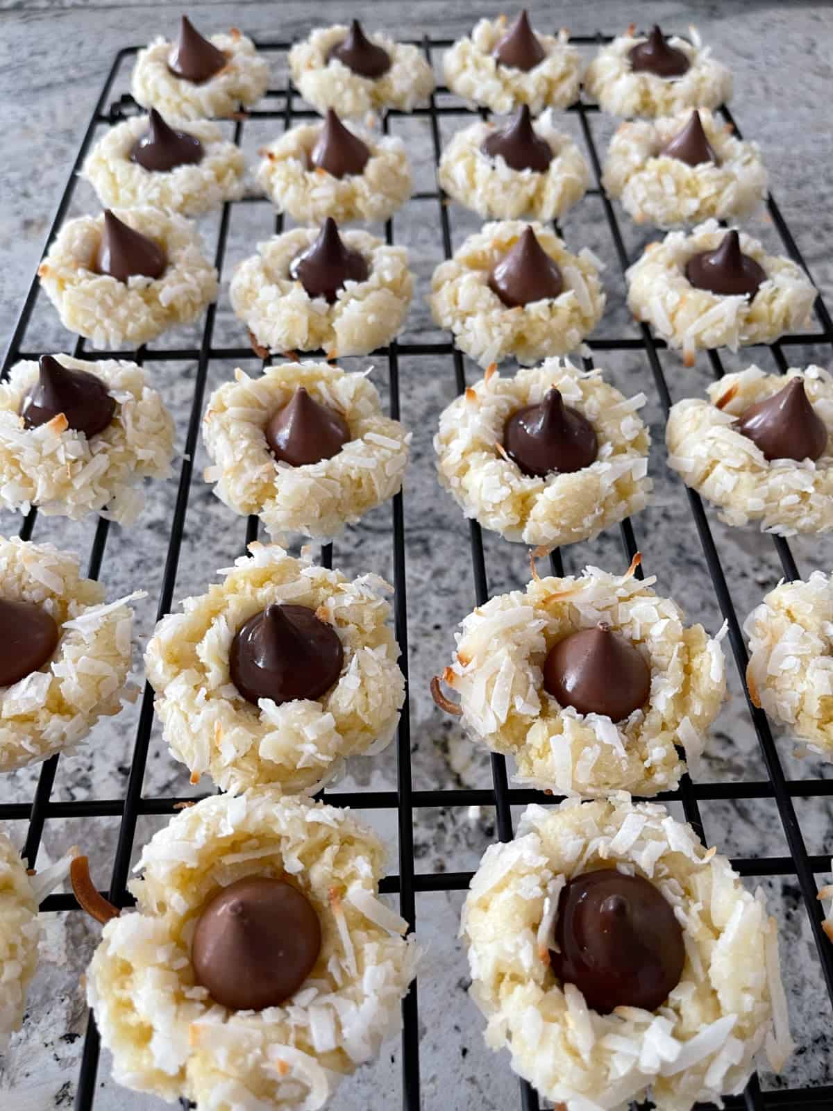 Coconut macaroon kiss cookies cooling on wire rack.