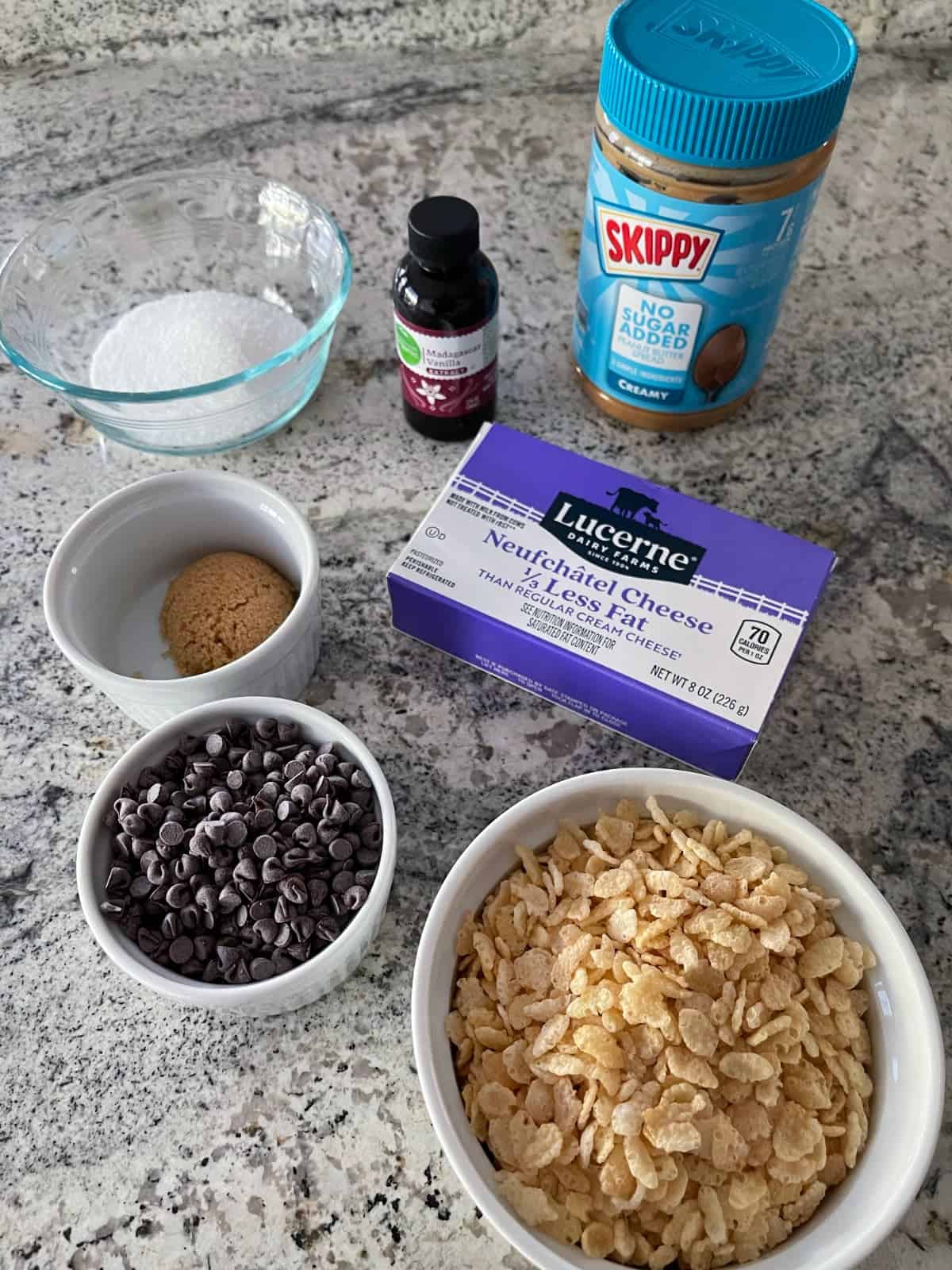 Ingredients including crispy rice cereal, mini chocolate chips, Truvia brown sugar, light cream cheese, vanilla and jar of peanut butter.